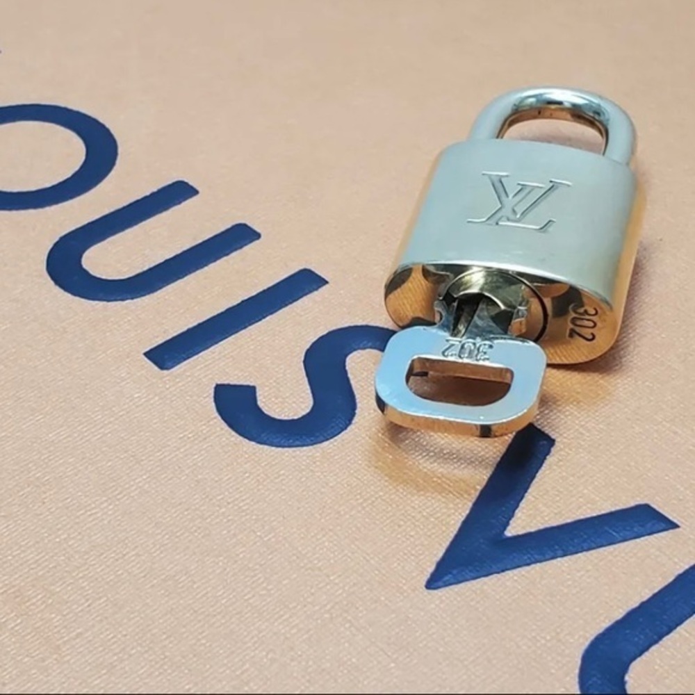 NEAR MINT Louis Vuitton lock and key set.